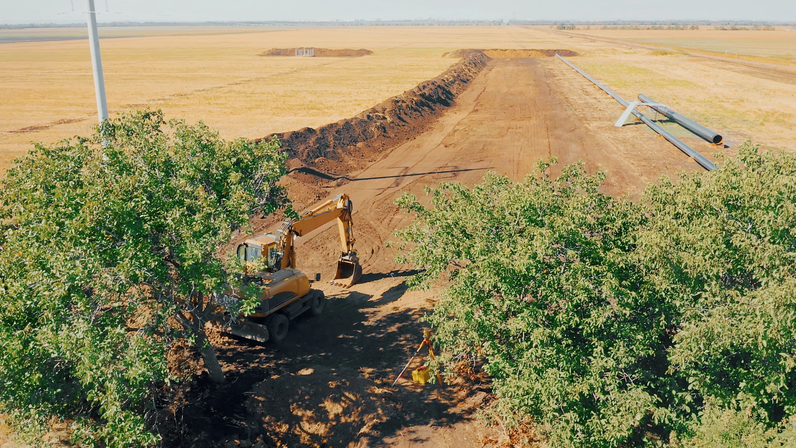 Excavator digging a trench at an active construction site